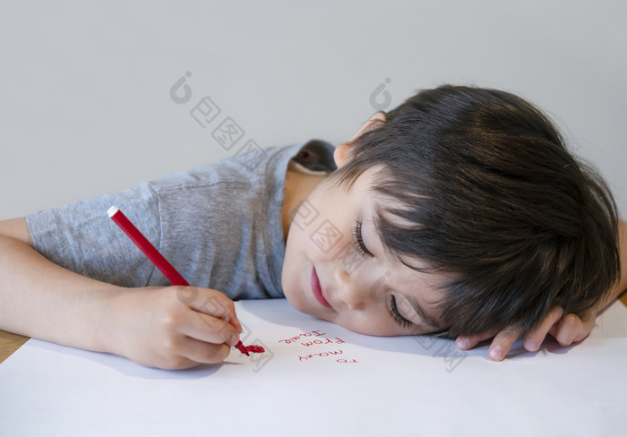 肖像快乐孩子写作消息他的妈妈。学前教育孩子使用红色的颜色写作和画白色纸小男孩说谎头下来表格画红色的心为我