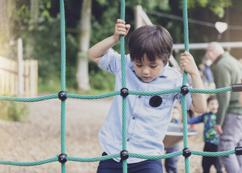 活跃的孩子攀爬绳子的操场上孩子享受活动攀爬冒险公园夏天阳光明媚的一天可爱的小男孩有有趣的操场上在户外