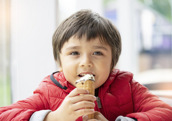 肖像快乐孩子吃冰奶油微笑孩子男孩坐着咖啡馆与快乐脸享受他的冰奶油春天夏天家庭放松周末概念