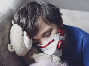 男孩累了从胸部咳嗽穿脸面具为保护孩子下降睡眠而玩
