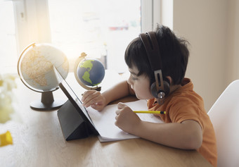 肖像学前教育孩子使用平板电脑为他的家庭作业软焦点孩子做家庭作业使用数字平板电脑搜索信息互联网首页学校教育教育概念