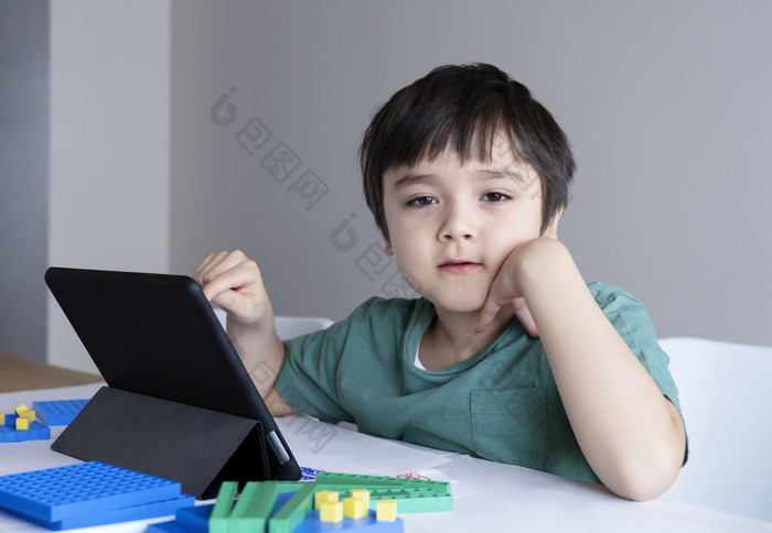 孩子保持首页看卡通特布莱特孩子使用数字平板电脑搜索信息互联网为他的家庭作业在新冠病毒锁下来社会距离学习在线教育