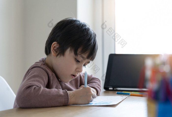 孩子自我隔离使用平板电脑为他的家庭作业孩子做使用数字平板电脑搜索信息互联网在科维德锁下来首页学校教育社会距离电子学习在线教育