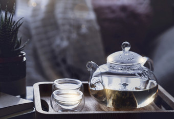 仍然生活清晰的能茶和两个杯与光蒸汽服务托盘咖啡表格与早....光可以舒适的场景下午茶与玻璃茶壶书和能植物柔和的