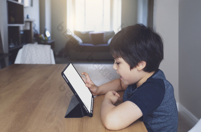 孩子使用平板电脑研究家庭作业孩子使用数字平板电脑为他的在线教训首页在检疫首页学校教育社会距离和电子学习在线教育概念