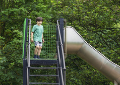 肖像孩子站幻灯片户外操场上夏天孩子享受活动攀爬冒险公园夏天男孩有有趣的学校院子里玩和学习概念