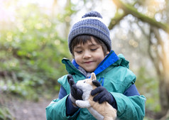 肖像快乐孩子穿冬天衣服玩与狗玩具的公园孩子资源管理器和学习关于野生自然农村小男孩冒险森林与学校旅行