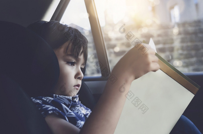 孩子选址车座位和阅读书小男孩坐着的车孩子安全座位肖像蹒跚学步的娱乐himserf路旅行概念安全塔维尔酒车与孩子们