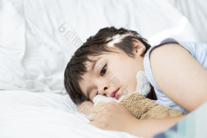 孩子一年老说谎床上困了孩子醒着的的早....他的床上房间与早....光可爱的小男孩睡觉与他的狗玩具床上孩子们健康哪睡眠问题年轻的