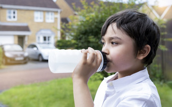 孩子喝水渴了男孩持有瓶水健康的孩子与新鲜的脸后喝水而走世界水一天孩子们健康哪