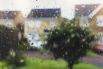 雨滴窗口玻璃多雨的一天与模糊的树和房子背景视图看槽窗口与水滴纹理采取后的雨在路背景