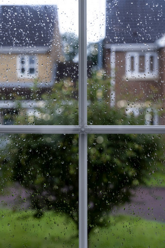 雨滴窗口玻璃多雨的一天与模糊的树和房子背景视图看槽窗口框架与水滴纹理采取后的雨在路背景