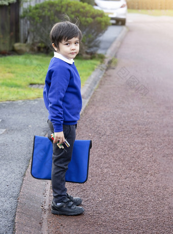 肖像孩子持有玩具和携带袋等待为校车学生主学校得到准备好了研究学生回来学校第一个一天小学学生
