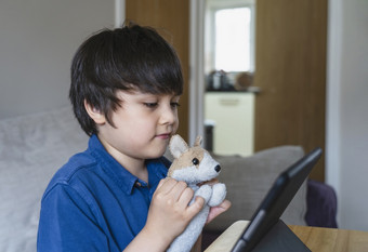 微笑高加索人男孩有视频调用遥远的类与老师平板电脑快乐孩子显示他的玩具朋友数字平板电脑在家教育社会距离教育概念