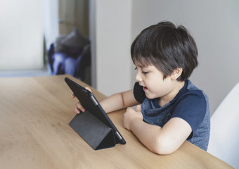 孩子使用平板电脑研究家庭作业孩子使用数字平板电脑为他的在线教训<strong>首页</strong>在检疫<strong>首页</strong>学校<strong>教育</strong>社会距离和电子学习在线<strong>教育</strong>概念