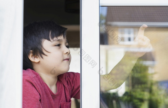 积极的孩子男孩坐着的窗口写作玻璃与微笑脸学校孩子自我隔离放松首页在科维德首页学校教育距离教育