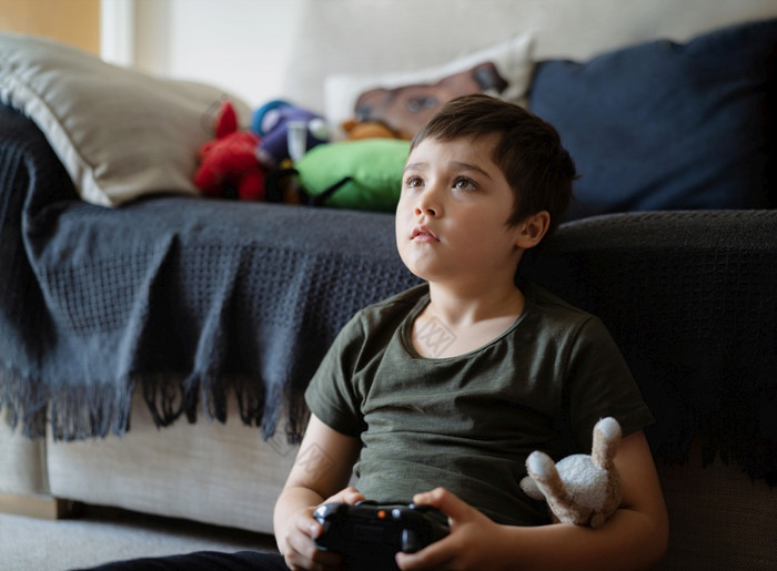 肖像快乐孩子持有视频游戏游戏控制台孩子玩游戏在线首页年轻的男孩选址地毯有有趣的和放松他的自己的周末新正常的生活方式概念