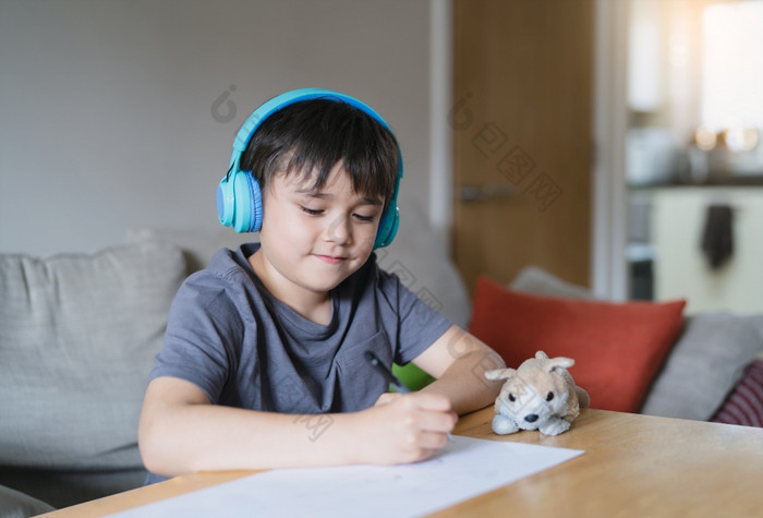 快乐孩子穿耳机听音乐而画纸在室内肖像可爱的孩子男孩享受有创意的活动首页周末