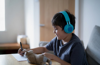 快乐孩子穿一些耳机和听音乐而画纸室内肖像可爱的男孩享受有创意的<strong>活动首页</strong>周末孩子做家庭作业