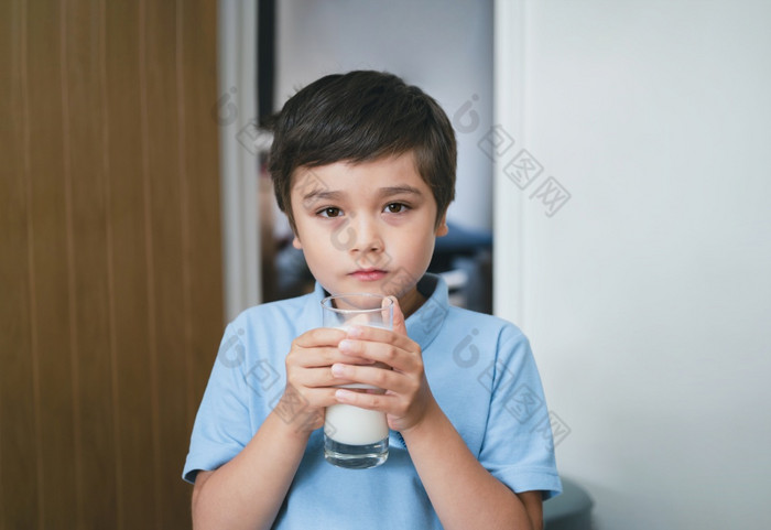 肖像健康的学校男孩喝玻璃牛奶为早餐快乐孩子站厨房喝温暖的牛奶之前学校希希蒂食物liftstyle概念