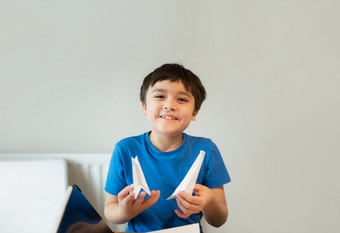 快乐学校男孩看相机与微笑脸而显示折纸天鹅纸孩子学习纸艺术折纸教训孩子有有趣的做艺术和工艺首页首页学校教育概念