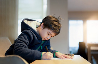 学校孩子使用黑色的笔画写作的<strong>信纸</strong>年轻的男孩做家庭作业孩子与笔写作笔记纸表在的教训可爱的学生做测试在家教育概念