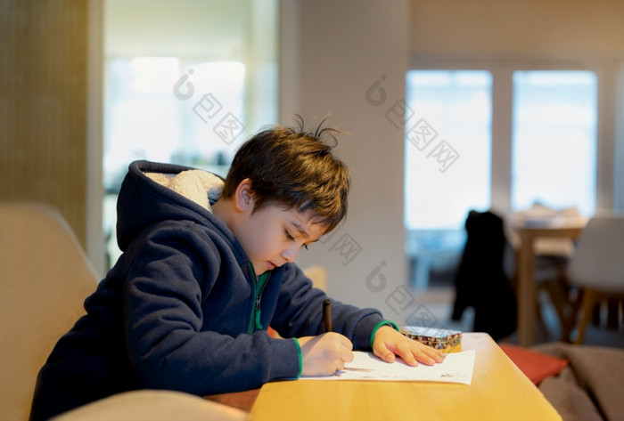 学校孩子使用黑色的笔画写作的信纸年轻的男孩做家庭作业孩子与笔写作笔记纸表在的教训可爱的学生做测试在家教育概念