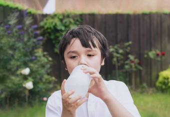 孩子喝水渴了男孩持有瓶水孩子喝水而玩的花园世界孩子们一天世界环境一天