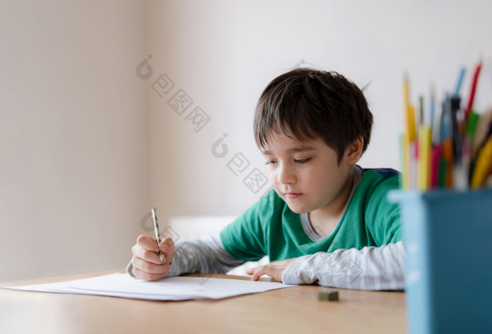 快乐男孩使用铅笔画草图纸肖像孩子选址表格做家庭作业孩子享受艺术和工艺活动首页教育概念