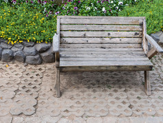 木板凳上的砖地板上附近的花圃的公共公园