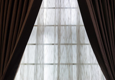 棕色（的）窗帘与半透明的织物的窗口生活房间