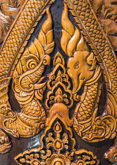 老雕刻大象和龙木柱子的泰国寺庙