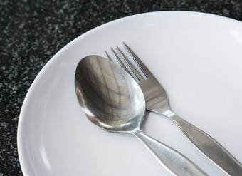 老条子勺子和叉的白色陶瓷板的当地的餐厅