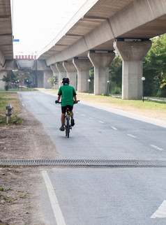 的现代自行车骑慢慢地下的表达道路附近的城市公园