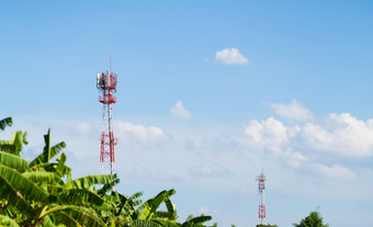 移动网络细胞沟通塔在<strong>草木</strong>丛生的对的蓝色的天空背景
