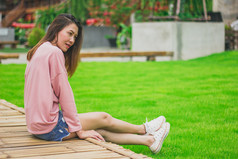 女人穿粉红色的衬衫坐着竹子桥