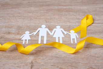 自杀预防和童年癌症意识黄色的丝带和家庭纸形状为支持人生活和疾病孩子们医疗保健和世界癌症一天概念