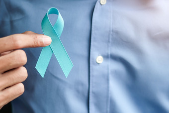 前列腺癌癌症意识男人。持有光蓝色的丝带为支持人生活和疾病但医疗保健和世界癌症一天概念
