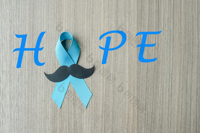 前列腺癌癌症意识光蓝色的丝带与胡子木背景为支持人生活和疾病但医疗保健和世界癌症一天概念