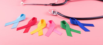 世界癌症一天2月色彩斑斓的意识丝带蓝色的红色的绿色粉红色的和黄色的颜色木背景为支持人生活和疾病医疗保健和医学概念