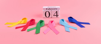 世界癌症一天2月色彩斑斓的意识丝带蓝色的红色的绿色粉红色的和黄色的颜色木背景为支持人生活和疾病医疗保健和医学概念