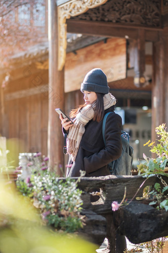 快乐年轻的女人旅行者使用移动电话shelfie摄影丽江老小镇具有里程碑意义的为旅游景点丽江云南中国亚洲旅行概念