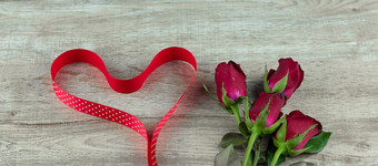 红色的玫瑰花和心形状丝带木表格背景爱浪漫的和快乐情人节一天假期概念