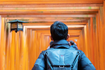 年轻的男人。旅行伏见inari大社神社快乐亚洲旅行者看充满活力的橙色鸟居盖茨具有里程碑意义的和受欢迎的为<strong>游客景点</strong>《京都议定书》日本亚洲旅行概念