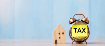 时钟与税文本和房子模型木背景银行真正的房地产财产投资首页抵押贷款金融和时间税概念