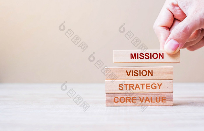 商人手持有木建筑块与任务愿景核心价值和策略词业务概念