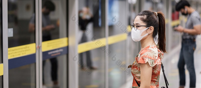 年轻的亚洲女孩穿外科手术脸面具保护冠状病毒变形快乐旅游女人等候公共火车社会距离新正常的和生活后新冠病毒流感大流行