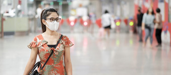年轻的亚洲女孩穿外科手术脸面具保护冠状病毒变形快乐旅游女人走公共地铁站社会距离新正常的和生活后新冠病毒流感大流行
