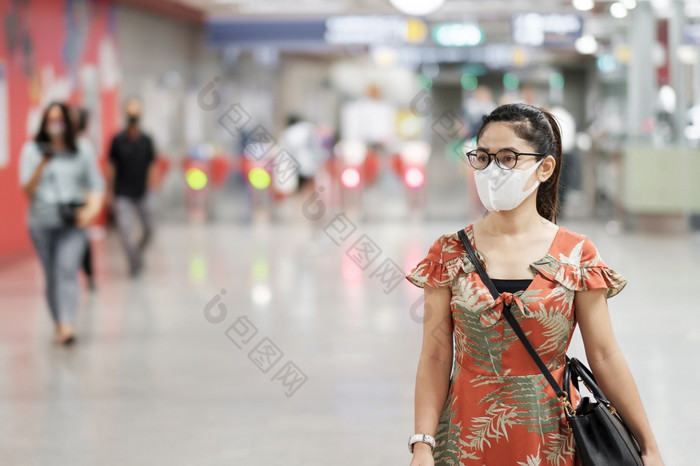 年轻的亚洲女孩穿外科手术脸面具保护冠状病毒变形快乐旅游女人走公共地铁站社会距离新正常的和生活后新冠病毒流感大流行