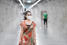 年轻的亚洲女孩穿外科手术脸面具保护冠状病毒变形快乐旅游女人走公共地铁站社会距离新正常的和生活后新冠病毒流感大流行